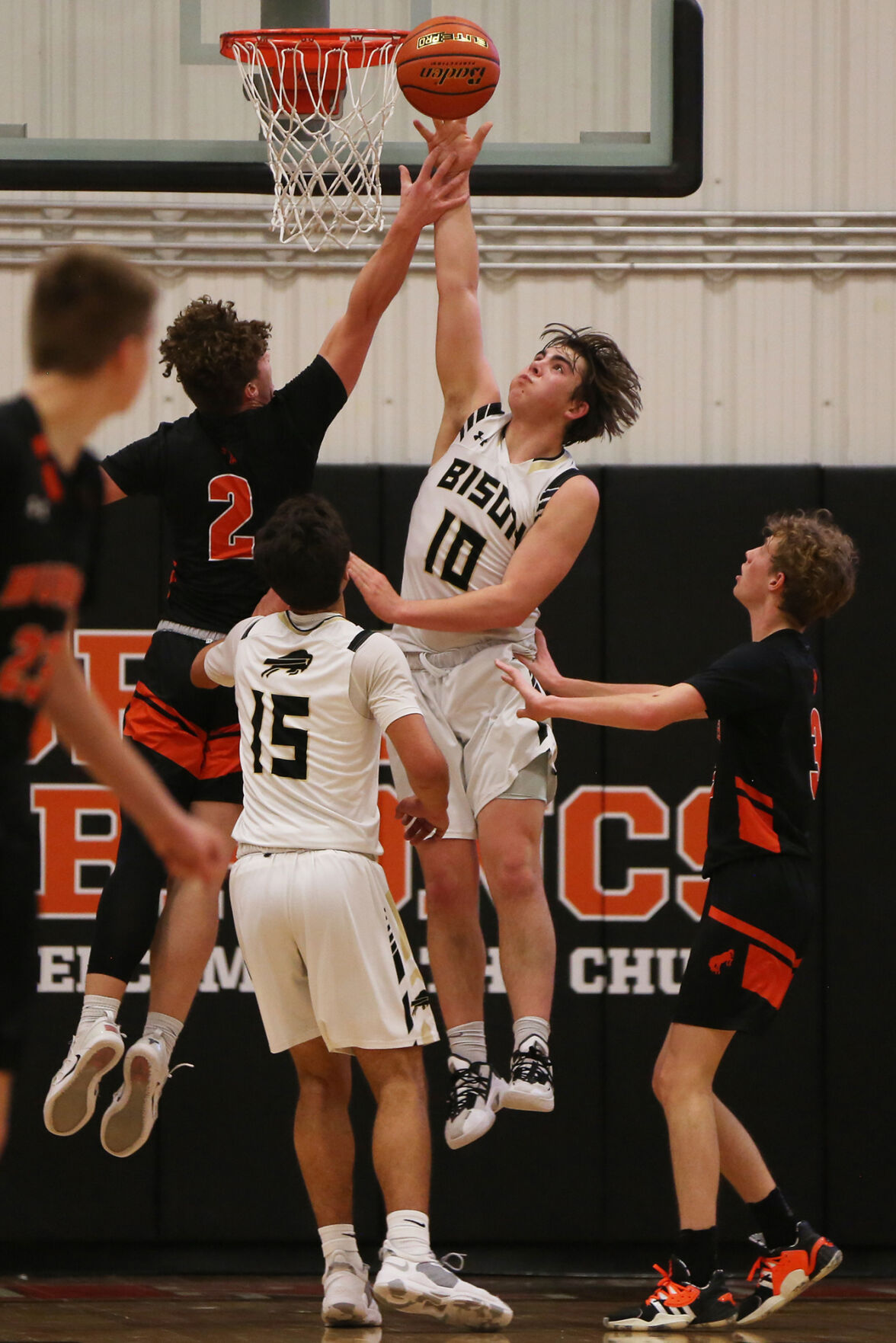 Jackson Moon stretches to successfully block the shot of Burns senior Caden David